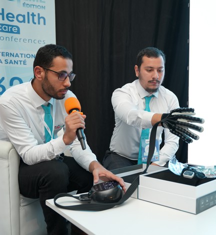 Deux exposants présentent un dispositif au micro sur leur stand
